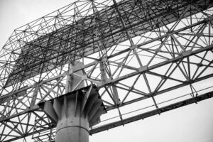 Schwarz-Weiß-Fotografie eines leeren Billboards in Thailand, aus der Froschperspektive aufgenommen. Die Stahlkonstruktion erinnert an ein Skelett. Teil der Serie Billboards von J.F. Lindemann, Leica M, Summicron 28mm ASPH