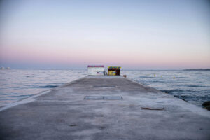 Geschlossene Strandkioske auf einer Mole in Antibes, Südfrankreich, mit Blick auf das Meer im Abendlicht – Fotografie aus der Serie FERMÉ-21 von J.F. Lindemann mit Leica M und Summicron 28mm ASPH