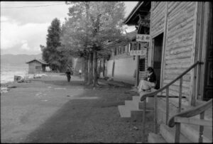 Straßenszene in Yunnan, China, mit Frau auf den Stufen und traditioneller Architektur, am Mono Lake Schwarzweiß-Fotografie von J.F. Lindemann, 1993