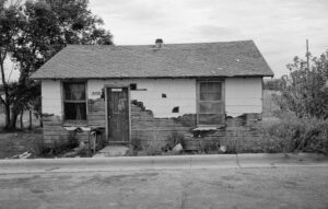 Bewohntes Haus mit sichtbaren Gebrauchsspuren im Pine Ridge Reservat, South Dakota, Schwarzweiß-Fotografie von J.F. Lindemann, 1994