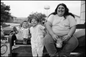 Familienporträt mit lachenden Kindern und Frau im Pine Ridge Reservat, South Dakota, Schwarzweiß-Fotografie mit Leica M6 und dem Summicron 35mmvon J.F. Lindemann, 1994