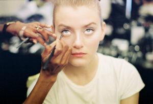 Make-up Artist schminkt ein Model backstage bei einer Haute Couture Show in Paris – Fotografie von J.F. Lindemann mit der Leica M6 und dem Noctilux 50mm f1.0