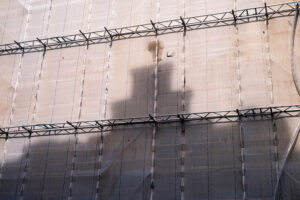 Baugerüst mit verhüllter Fassade, im Stoff zeichnet sich der Schatten eines Kirchturms ab · Serie WRAPPED von J.F. Lindemann · Leica M, Summicron-M 28mm f/2.0 ASPH