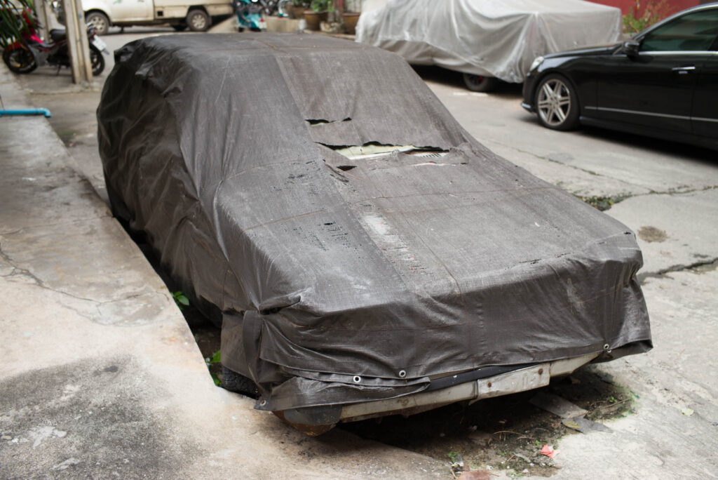 In dunklem Stoff verhülltes Auto in einer Seitenstraße von Bangkok, Teil der Serie WRAPPED, künstlerische Fotografie von J.F. Lindemann, aufgenommen mit Leica M und Summicron-M 28mm f/2.0 ASPH