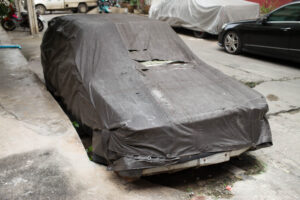 In dunklem Stoff verhülltes Auto in einer Seitenstraße von Bangkok, Teil der Serie WRAPPED, künstlerische Fotografie von J.F. Lindemann, aufgenommen mit Leica M und Summicron-M 28mm f/2.0 ASPH