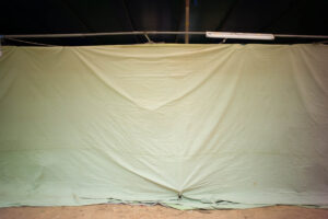 Grüne Plane mit Klebeband-Zeichen, gespannt als improvisierte Wand · Fotografie von J.F. Lindemann aus der Serie WRAPPED · Leica M6, 35mm Summicron