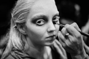 Backstage einer Modenschau – Model wird geschminkt, Nahaufnahme, Schwarzweiß