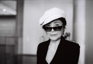 Yoko Ono mit Sonnenbrille und weißer Mütze, porträtiert von J.F. Lindemann mit Leica M6 und dem Summicron 35mm