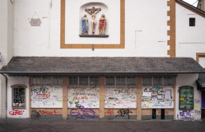 Geschlossene Ladenfassade an einer Kirche in Trier. – Fotografie aus der Serie FERMÉ von J.F. Lindemann mit Leica M11 und Summicron 28mm ASPH