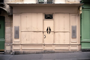 Geschlossene Ladenfassade in Beige mit grünen Türen in Paris – Fotografie aus der Serie FERMÉ von J.F. Lindemann mit Leica M und Summicron 28mm ASPH