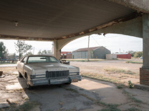 Ein alter Mercury unter einem Vordach an einem Zweckbau in Electra, Texas. Im Gegenlicht.