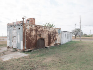 Stark verwittertes Nebengebäude mit Metallverkleidung in Electra, Texas.