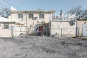 Gebäuderückseite mit asphaltierter Fläche und Spuren früherer Nutzung in Saint Petersburg, Florida.