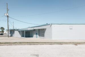 Flaches Industriegebäude mit heller Fassade und leerer Umgebung in Saint Petersburg, Florida.